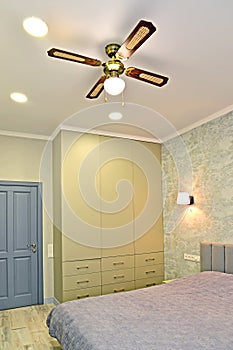 Interior of a modern bedroom with a fan chandelier on the ceiling