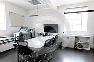 Interior of modern board room with conference table and swivel chairs, copy space