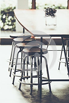 Interior of a modern coffee shop with loft style decoration with wooden concrete and steel wood table and chair , copy space