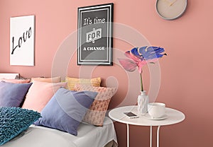 Interior of modern comfortable bedroom with color monstera leaf in vase on table