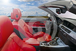 Interior of a modern convertible car with red leather seats