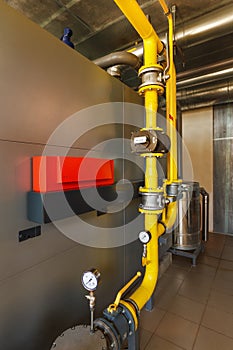 The interior of a modern gas boiler house with boilers, pumps, v