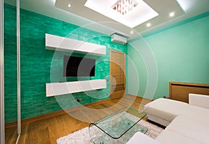 Interior of a modern green living room with luxury ceiling light