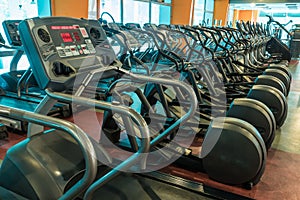 Interior of modern gym fitness room with large windows and treadmills