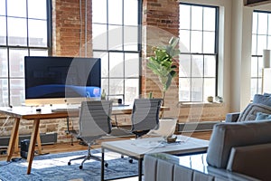 Interior of modern home office in loft style luxury studio apartment. Workspace with table, office chairs and desktop