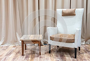 Interior of a modern hotel room with armchair and wooden coffee table