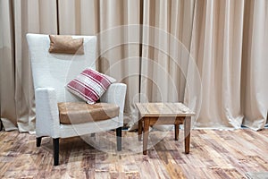 Interior of a modern hotel room with armchair and wooden coffee table