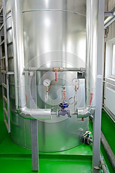 The interior of a modern industrial gas boiler room. Pipelines, water pumps, valves, manometers.