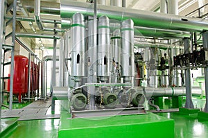 The interior of a modern industrial gas boiler room. Pipelines, water pumps, valves, manometers.