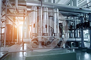 The interior of a modern industrial gas boiler room. Pipelines, water pumps, valves, manometers.