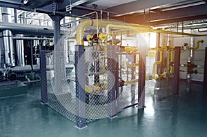 The interior of a modern industrial gas boiler room. Pipelines, water pumps, valves, manometers.