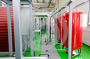 The interior of a modern industrial gas boiler room. Pipelines, water pumps, valves, manometers.