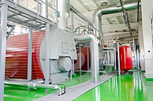 The interior of a modern industrial gas boiler room. Pipelines, water pumps, valves, manometers.