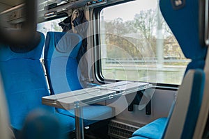 Interior of a modern intercity express train. Back view of wide comfortable seats in row at railroad transport. Empty