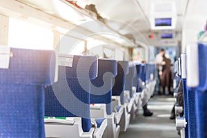 Interior of modern intercity express train. Back view of wide comfortable seats in row at railroad transport. Sunrise