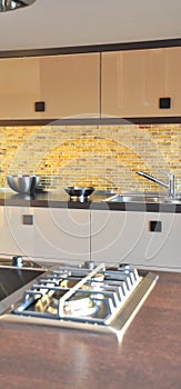 Interior of modern kitchen equipment, brown and beige cabinets