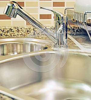 Interior of modern kitchen and stainless steel sink, tap and drain