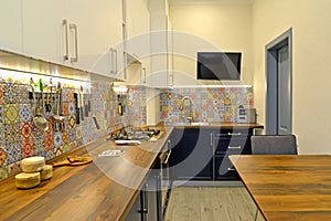 Interior of a modern kitchen with a TV on the wall