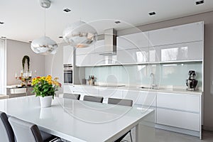 interior of modern kitchen with white furniture and dining area, nobody inside