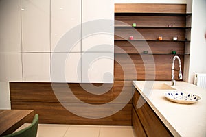 Interior of modern kitchen, white and walnut cabinets