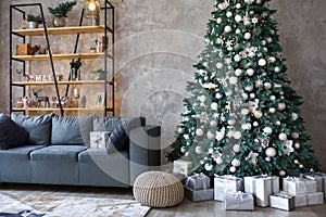 Interior of modern living room with comfortable sofa decorated with Christmas tree and gifts