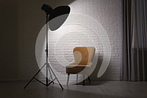 Interior of modern photo studio with professional lighting and armchair