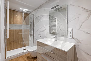 Interior of modern refurbished bathroom with shower with wooden finishing