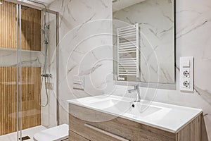 Interior of modern refurbished bathroom with shower with wooden finishing