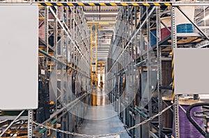 Interior of a modern storage warehouse with coils of colored cable on metal shelves. Forklift lift at the factory