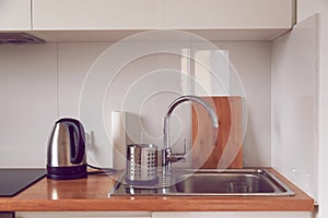 Interior of modern stylish kitchen in minimalist or scandinavian style. Faucet, sink, cutting board