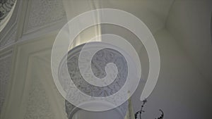 Interior of the mosque with decorative ceiling and walls. Scene. White beautiful mosque with marble columns.