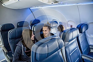 Interior of a nearly empty airplane. Photo of a family sitting near the back of the plane on a not full flight.