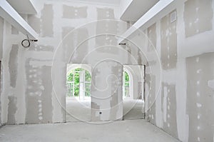 Unpainted interior of a new home under construction, showcasing unfinished drywall