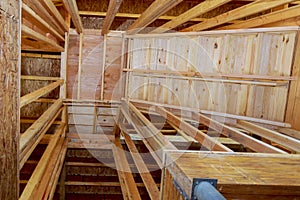 Interior of a new home under construction, with stairs to an opening for wooden beams