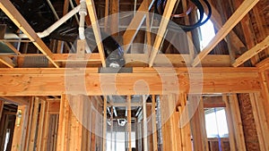 Interior of a new home wooden beams at construction residential house framing