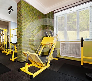 Interior of new light modern gym in green colors with yellow equipment