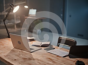 interior of a night office with a desk and an open laptop .