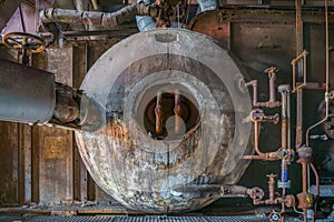 Interior of an old abandoned manufacturing building with rusty machinery