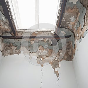 Interior of old building water damage causes cracked ceiling