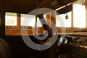 Interior of an old car in a sunlit garage