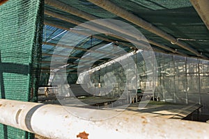 Interior of old destroyed greenhouses with broken window glasses. Empty building.