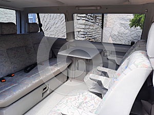 Interior of old luxury van with comfortable car passenger seat and table