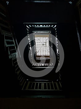 Interior of old renovated wooden square spiral staircase