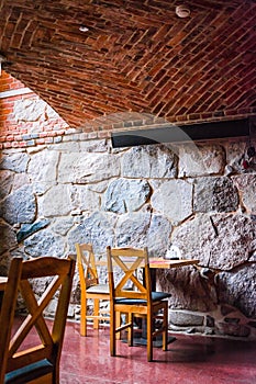 Interior of an old tavern, traditional old Poland cafe with brick wall chauirs and table, ghotic style cafe