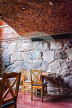 Interior of an old tavern, traditional old Poland cafe with brick wall chauirs and table, ghotic style cafe photo