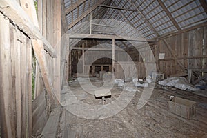 The interior of an old , unused , wooden barn .