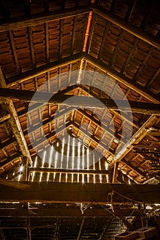 Interior of old wooden shed with scrap wood with sunrays