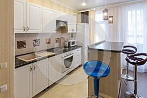 Interior of a one-room apartment, view of kitchen set and a bar counter