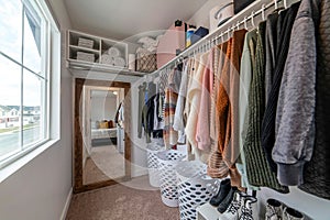 Interior of an organized walk in closer of home with mirror and built in shelves