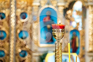 Interior of an Orthodox Ukrainian church. Interior of an Orthodox Ukrainian church. Burning red candle on a gilded candlestick or